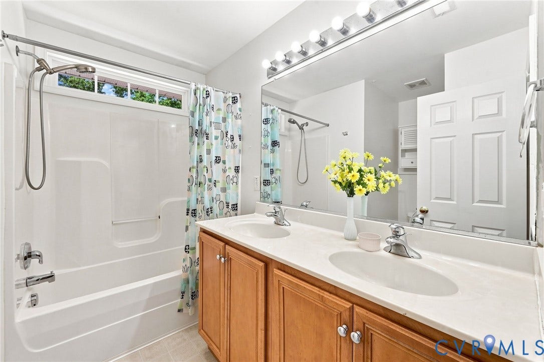 Double vanity with integrated sinks and wood-finish cabinetry