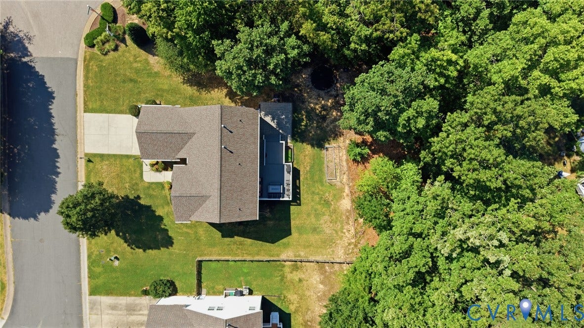 Expansive lot featuring mature trees, a private deck, and a manicured lawn