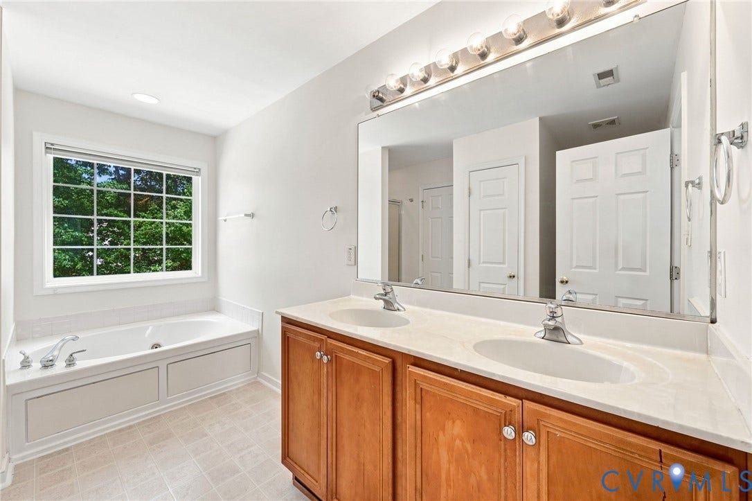 Double vanity with integrated sinks, light-toned countertop, and wood-finish cabinetry