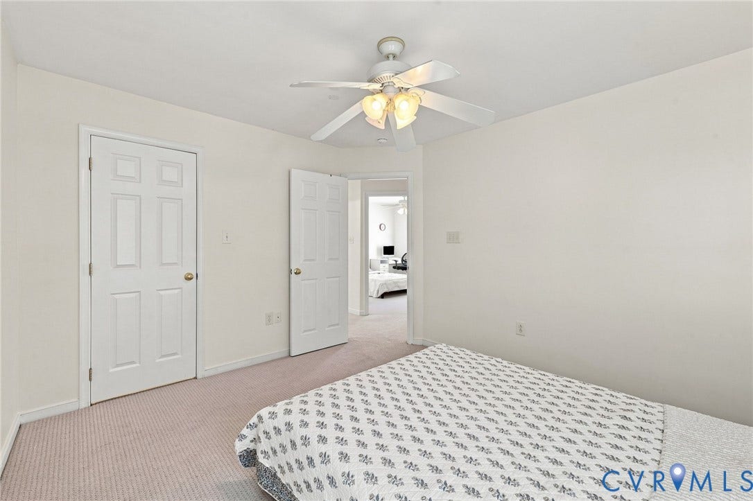 Neutral wall color, ceiling fan with integrated lighting, paneled interior doors, and carpet flooring