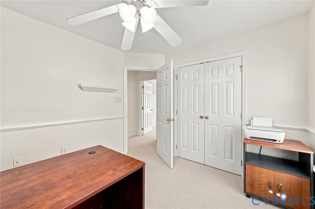 Neutral wall paint with chair rail molding, ceiling fan with integrated lighting, and carpeted flooring