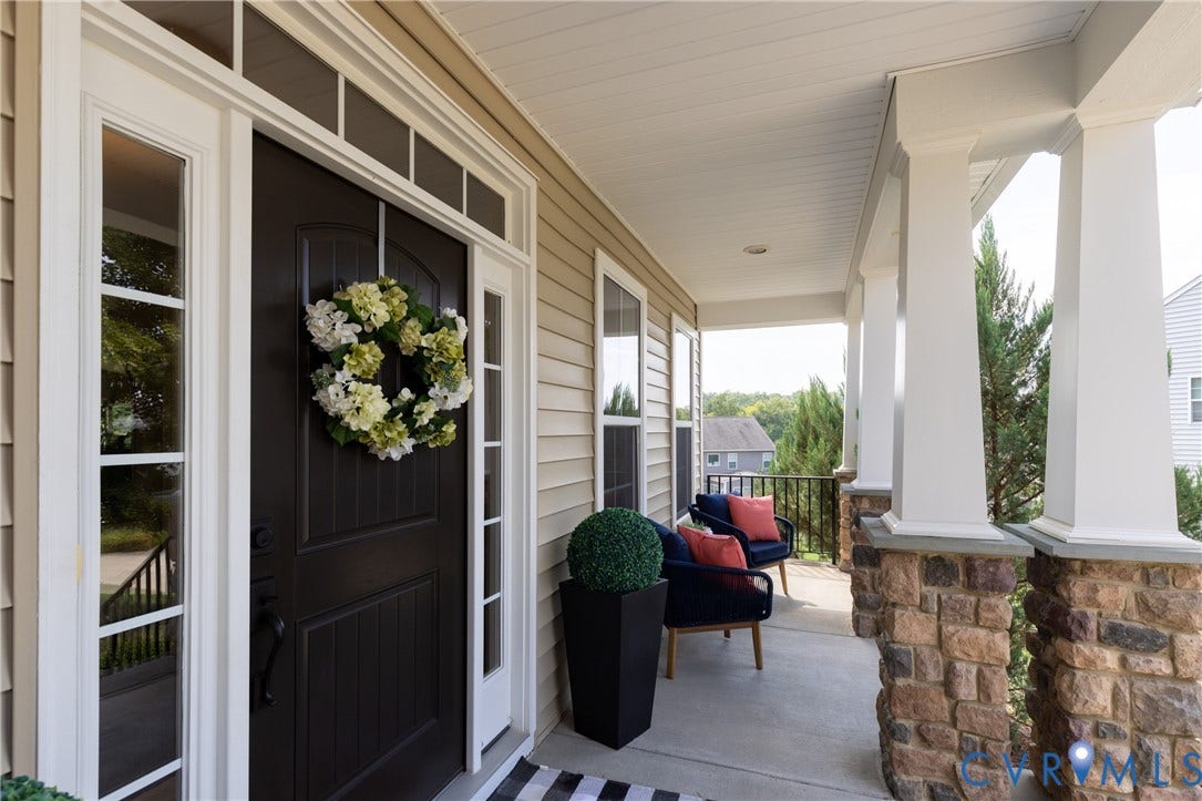 14806 Creekbrook Terrace, Brookcreek Estates, Midlothian, VA 23113 Inviting covered porch with stone-wrapped columns, a paneled entry door, and decorative sidelight windows