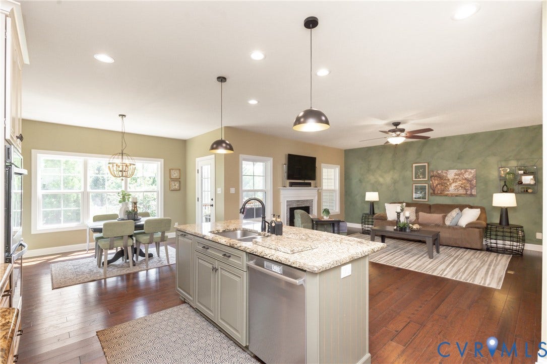14806 Creekbrook Terrace, Brookcreek Estates, Midlothian, VA 23113 Open-concept living area featuring hardwood flooring, a central kitchen island with a built-in sink, a fireplace with a mantel, and recessed lighting