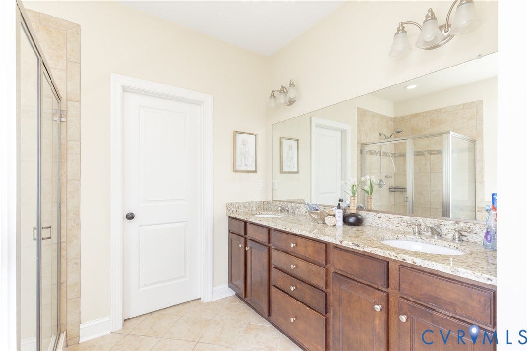 14806 Creekbrook Terrace, Brookcreek Estates, Midlothian, VA 23113 Dual vanity with granite countertop, integrated sinks, wood-finish cabinetry, and a full-width mirror