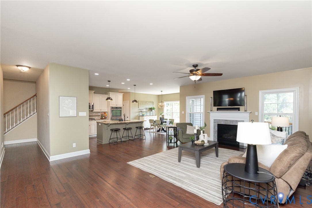 14806 Creekbrook Terrace, Brookcreek Estates, Midlothian, VA 23113 Wood-finish flooring throughout, a kitchen island with pendant lighting, a fireplace with a stone surround, and a ceiling fan