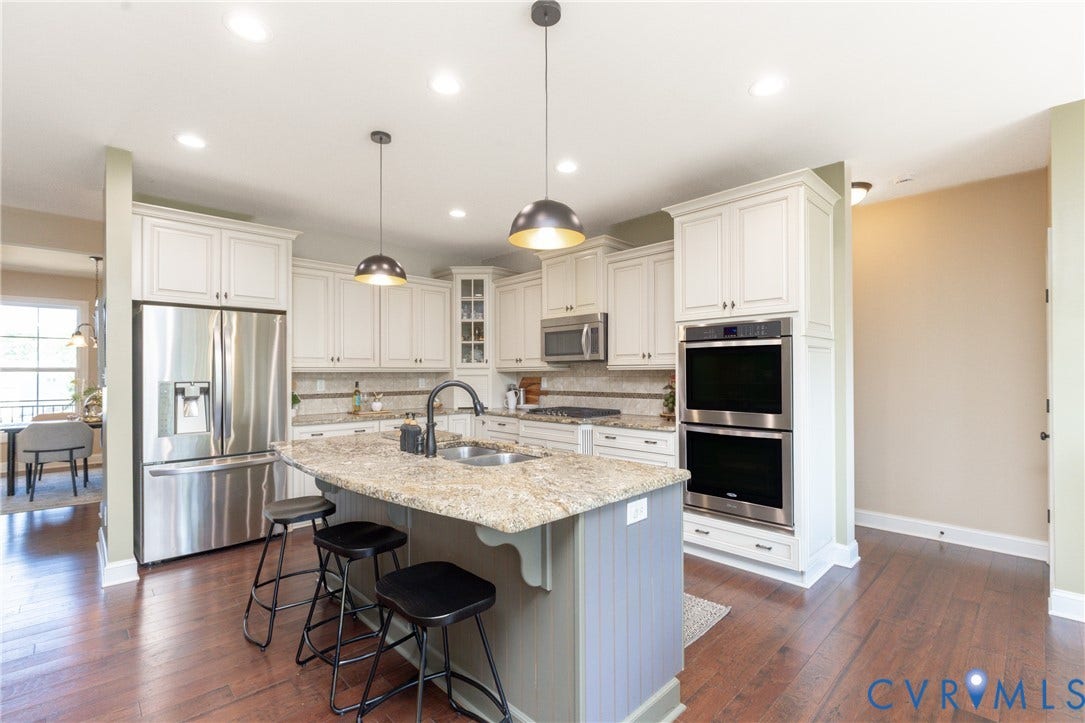 14806 Creekbrook Terrace, Brookcreek Estates, Midlothian, VA 23113 Kitchen featuring a central island with countertop seating, white cabinetry, stainless steel appliances, and wood-finish flooring