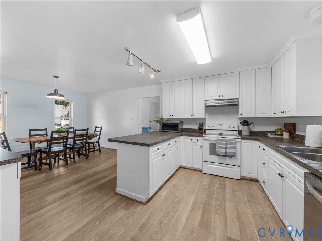 U-shaped kitchen with white cabinetry and dark countertops