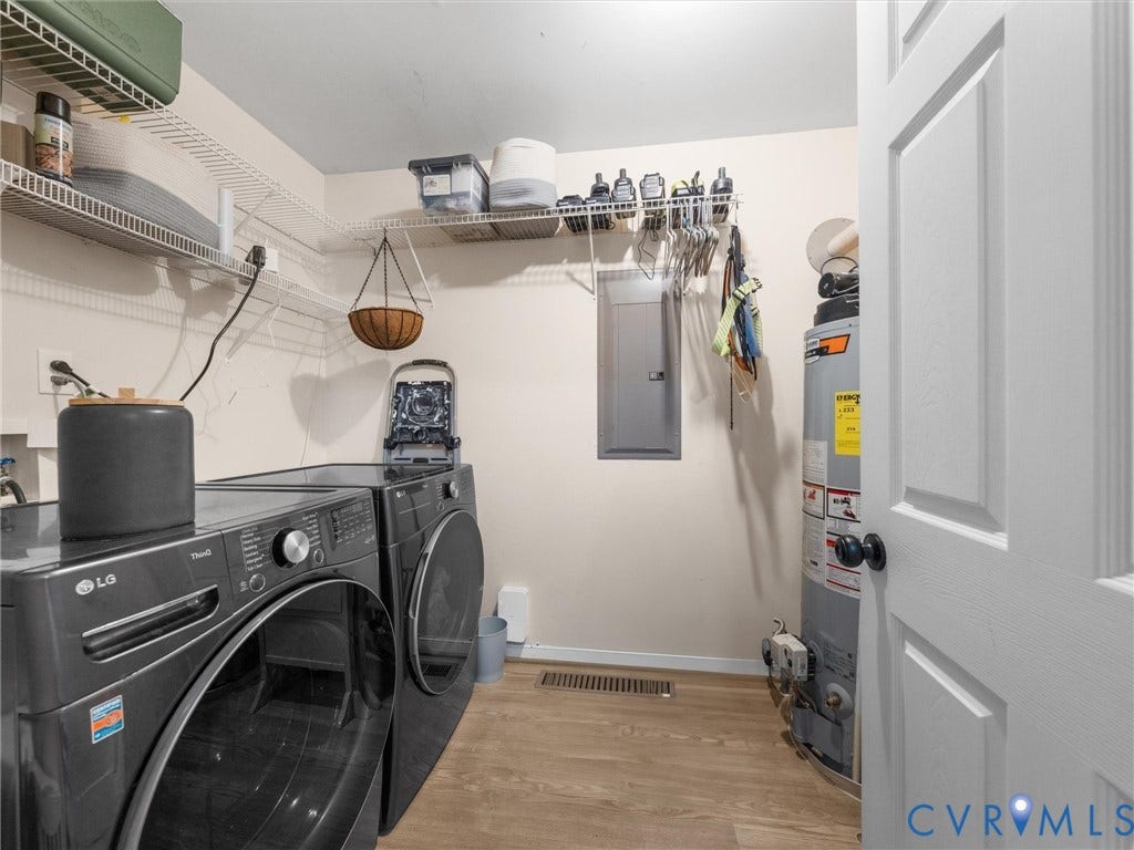 Laundry area featuring wood-finish flooring, white wire shelving, and a paneled interior door