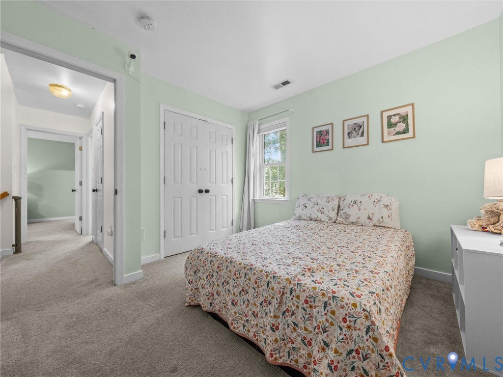 Carpeted room featuring a double-door closet, a window with exterior visibility, and light wall paint