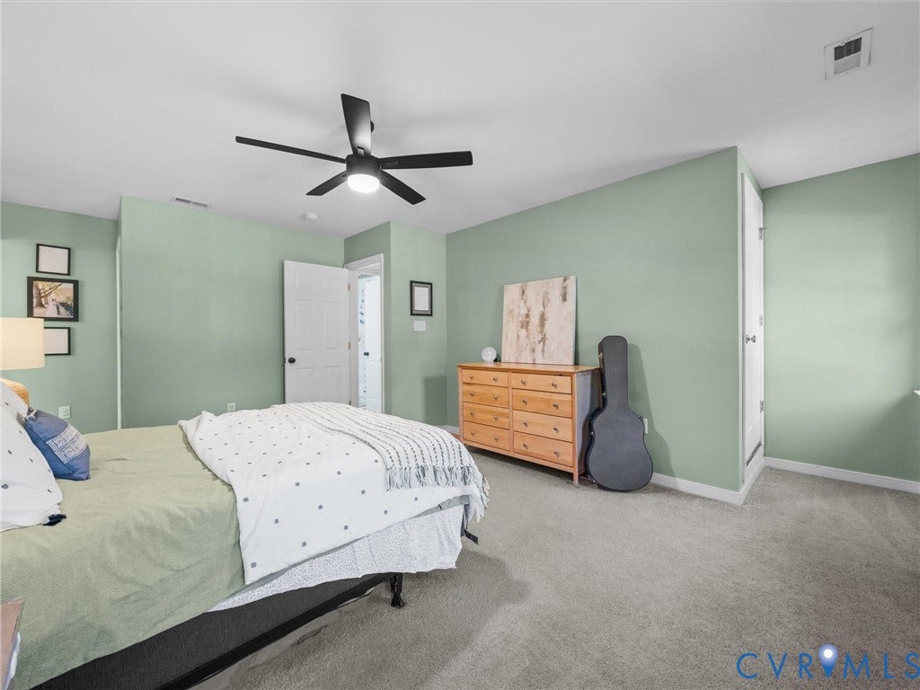 Carpeted room with light green walls, a ceiling fan, and white trim