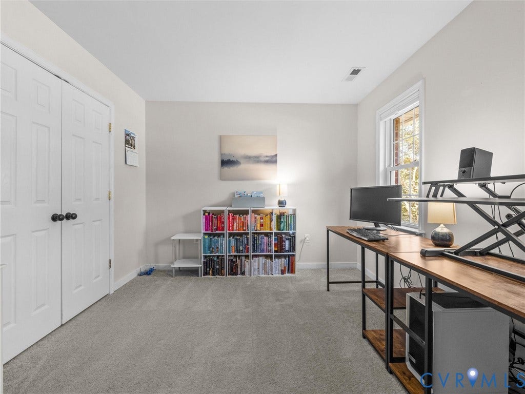 Light gray carpeting, white walls, double bi-fold doors with black hardware, and a single window with white trim