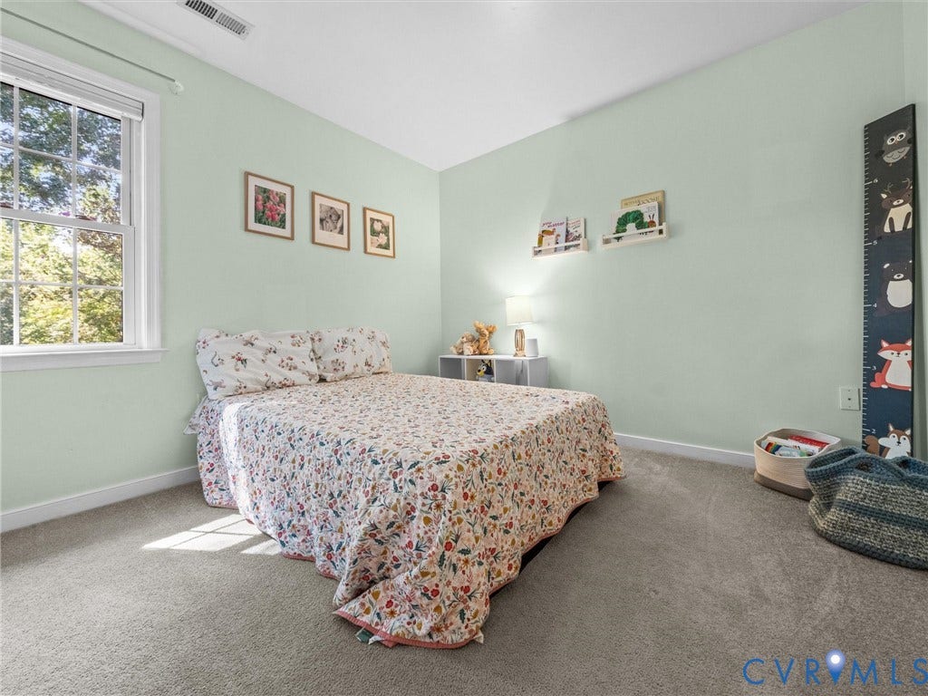 Wall-to-wall carpeting and a window with white trim