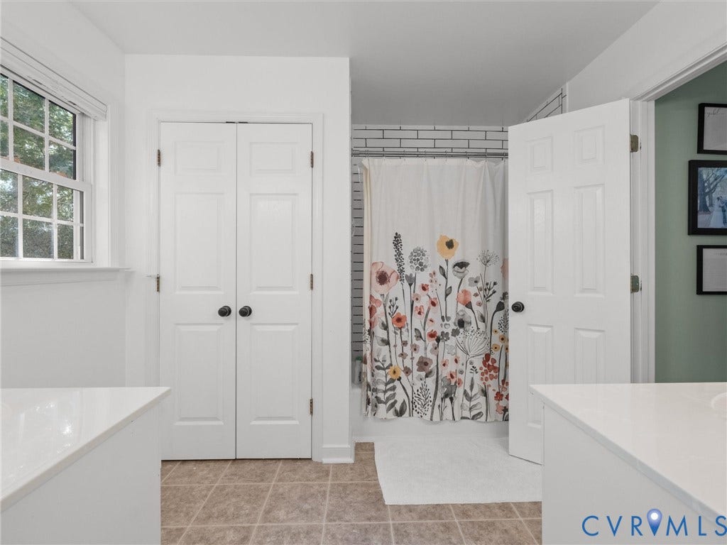 White paneled doors, tile flooring, window with grid panes, and white countertops