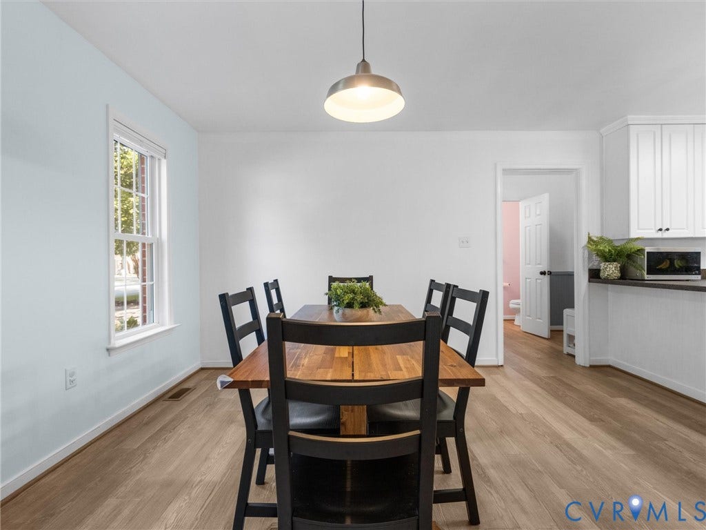 Wood-finish flooring throughout, with a recessed window and overhead pendant lighting