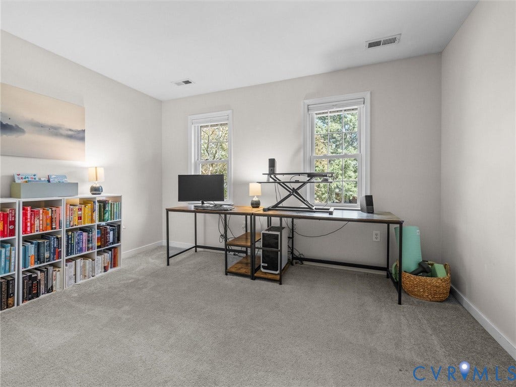 Recessed lighting, soft grey wall tones, and plush carpet flooring