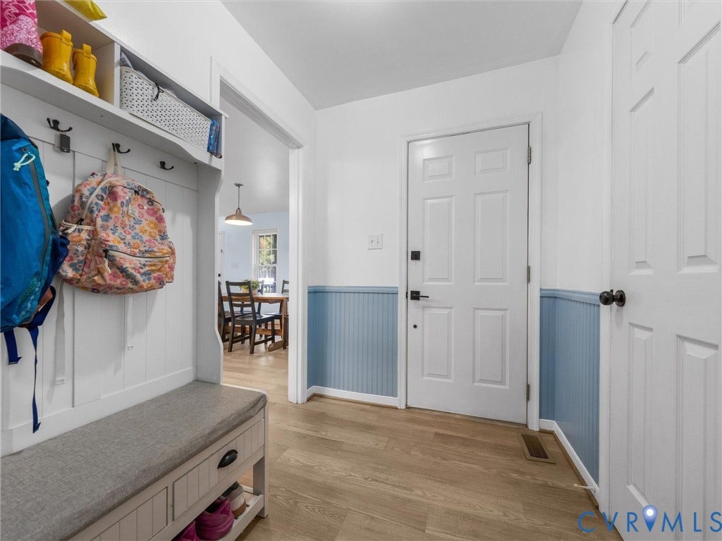 Wood-finish flooring, white paneled doors, and blue wainscoting