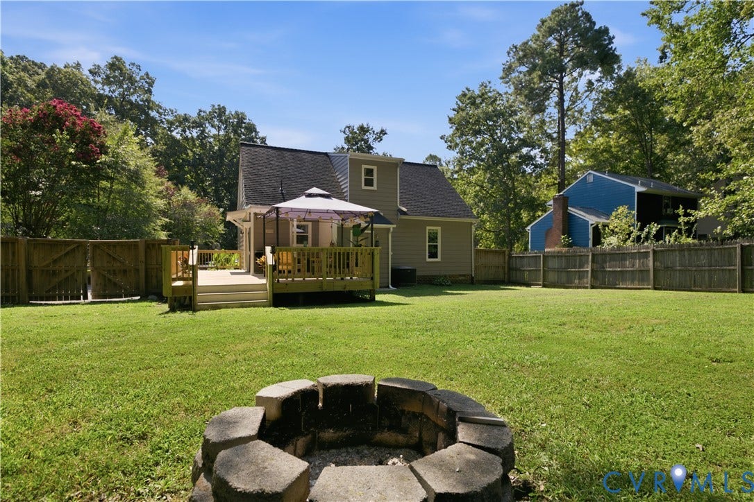 13602 Velvet Antler Place, Midlothian, VA 23112 Expansive backyard featuring a manicured lawn, a built-in fire pit, and a multi-level wood deck