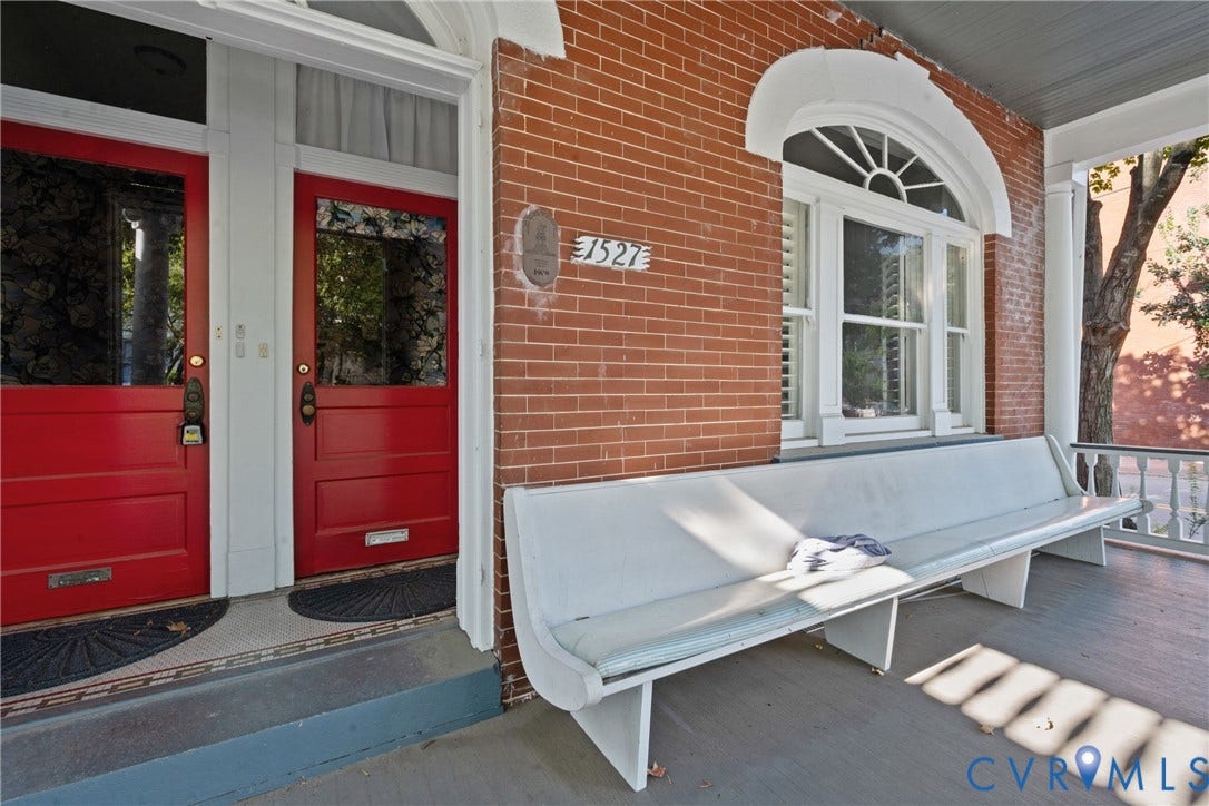 1527 Grove Avenue, #3, Richmond, VA 23220 Brick facade featuring a painted white porch bench, white porch railing, and two red entry doors with transom windows