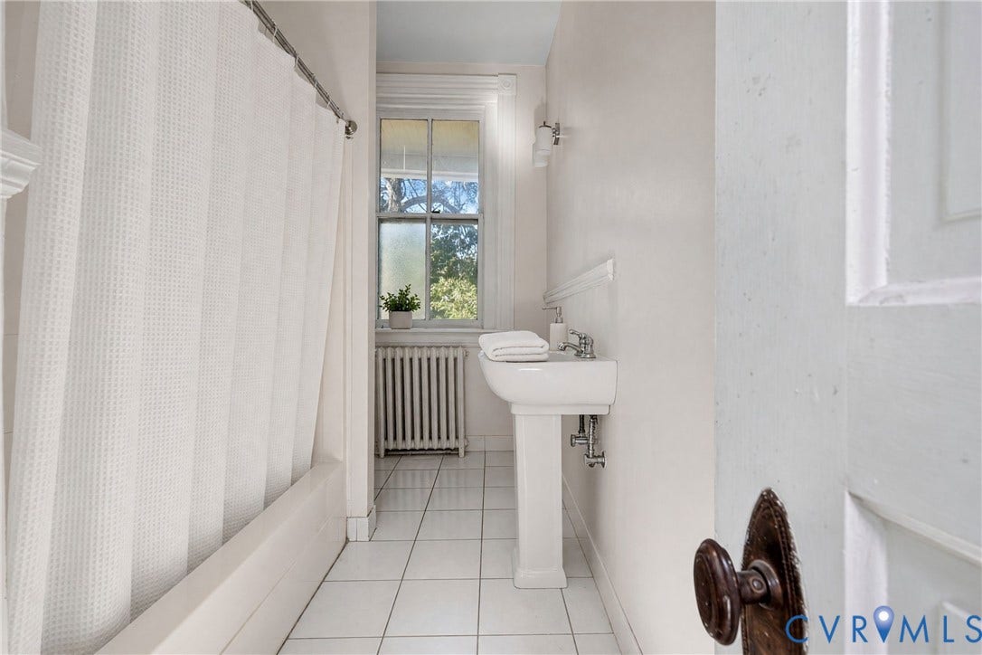 1527 Grove Avenue, #3, Richmond, VA 23220 Pedestal sink, wall-mounted sconces, tiled flooring, tub with shower, and window with natural light