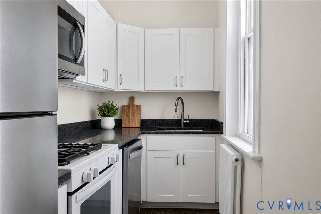 1527 Grove Avenue, #3, Richmond, VA 23220 White shaker cabinetry, dark countertops, integrated stainless steel appliances, and a window for natural illumination