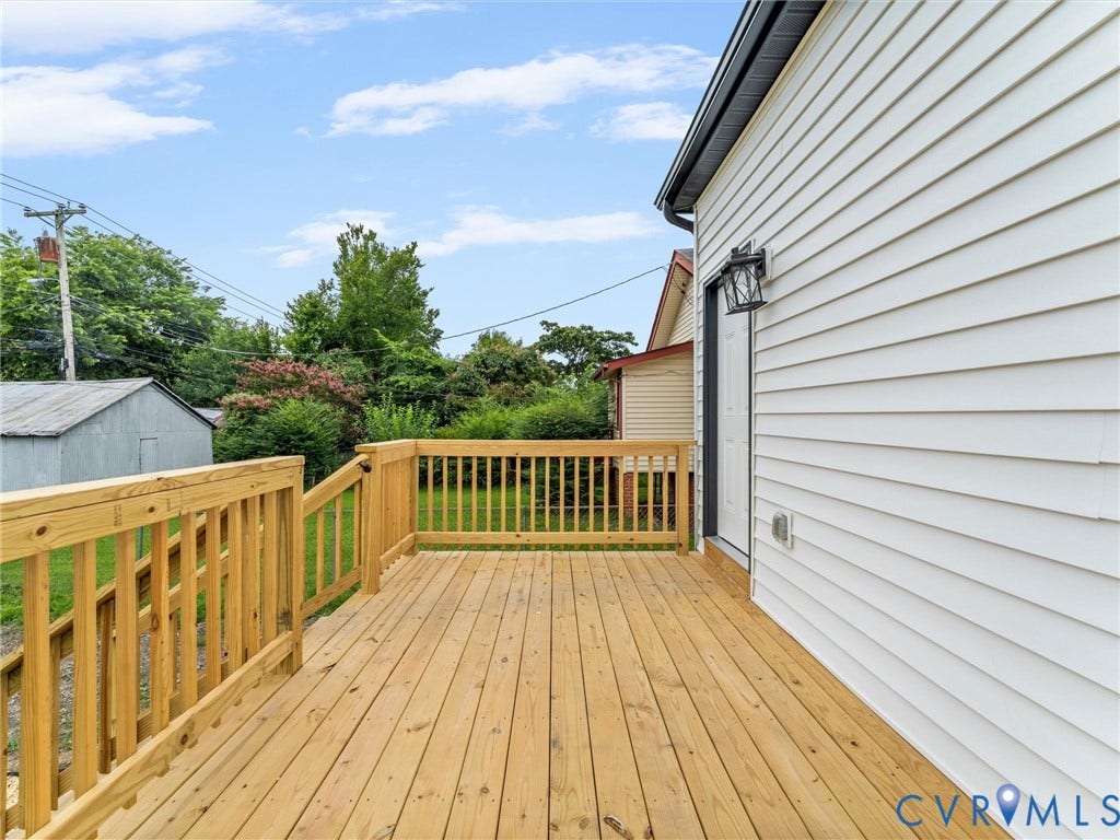2623 Northumberland Avenue, Richmond, VA 23220 Expansive wood deck with natural wood railing, white siding exterior, and exterior wall-mounted lighting