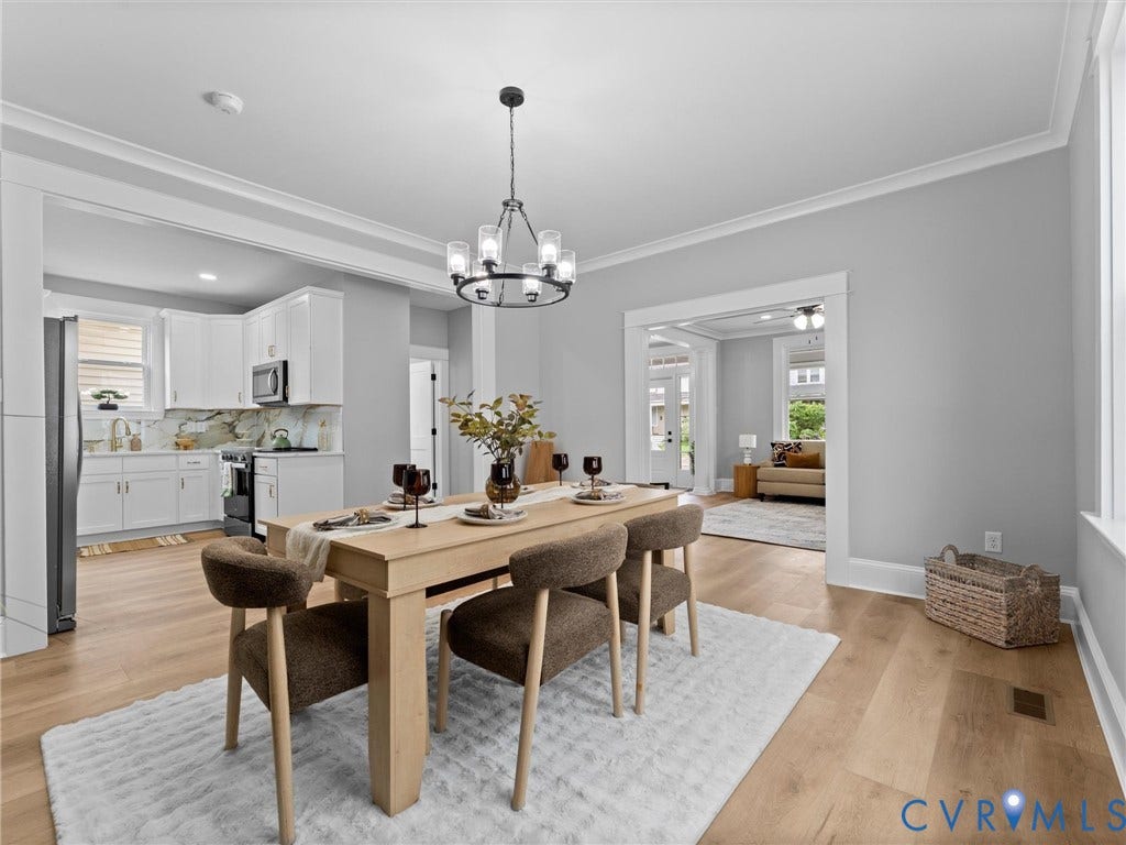2623 Northumberland Avenue, Richmond, VA 23220 Open-concept dining area with wood-finish flooring, crown molding, and a modern chandelier