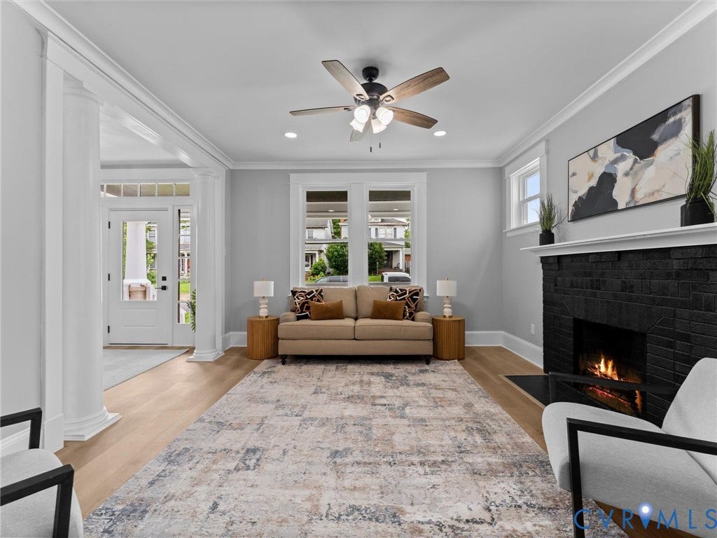 2623 Northumberland Avenue, Richmond, VA 23220 Hardwood flooring, black brick fireplace with white mantel, ceiling fan with integrated lighting, recessed lighting, and white trim work