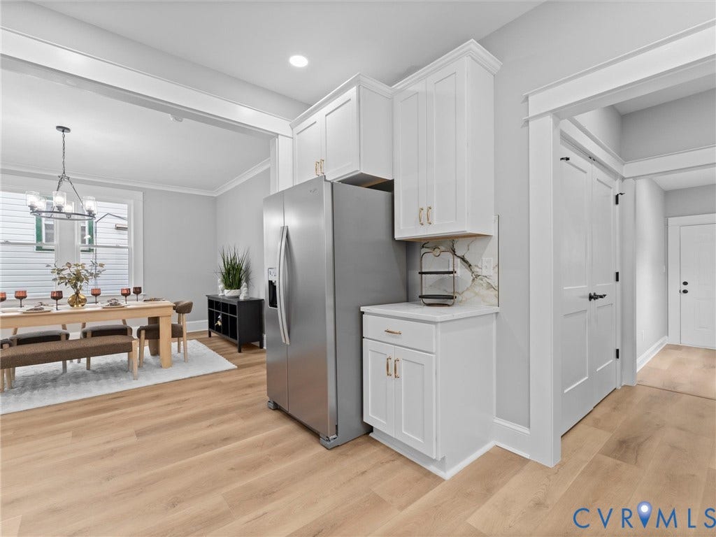 2623 Northumberland Avenue, Richmond, VA 23220 White shaker cabinetry with gold-finish hardware, stainless steel refrigerator, light wood-finish flooring, recessed lighting, and a decorative chandelier