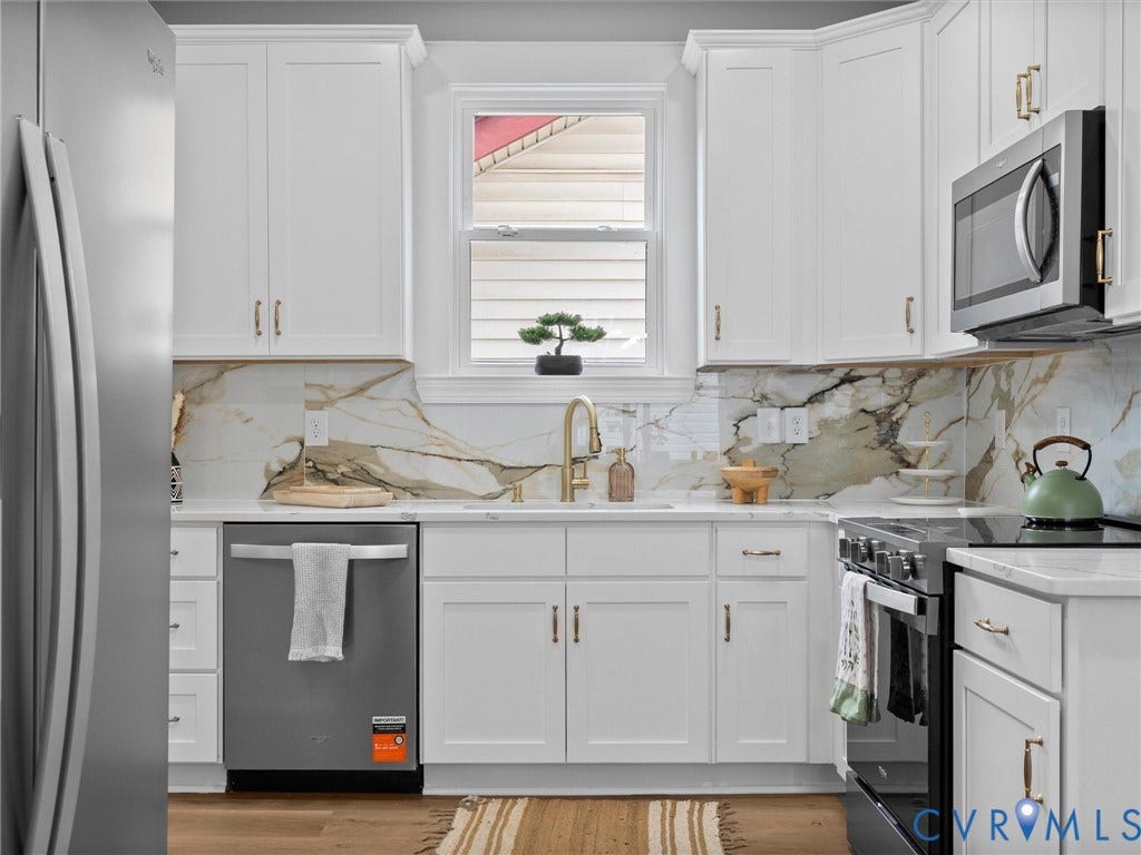 2623 Northumberland Avenue, Richmond, VA 23220 White shaker-style cabinetry with gold-tone hardware, a white countertop, and a marble-patterned backsplash