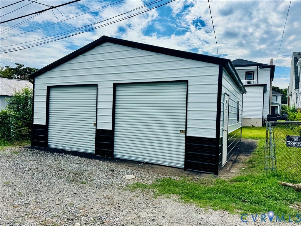 2623 Northumberland Avenue, Richmond, VA 23220 Detached garage with two roll-up doors, white siding, and a dark base