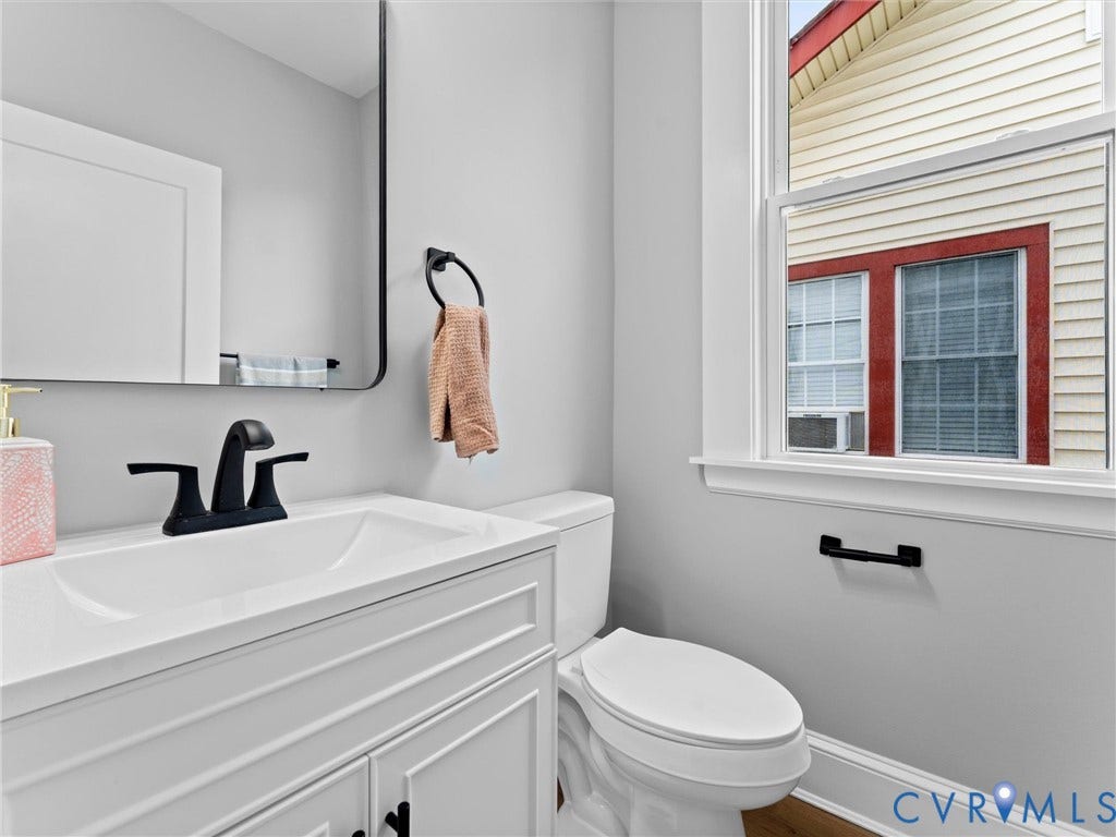 2623 Northumberland Avenue, Richmond, VA 23220 White vanity with integrated sink, matte black faucet, and coordinating hardware