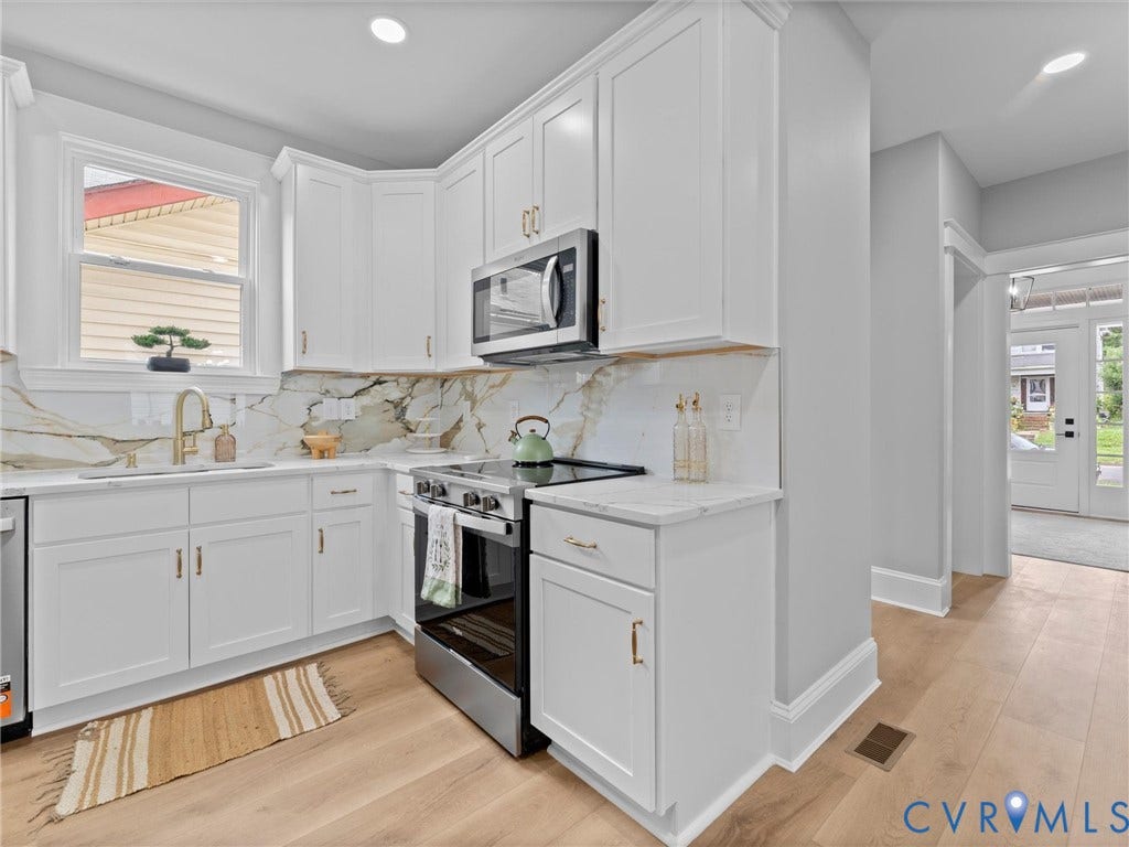 2623 Northumberland Avenue, Richmond, VA 23220 White cabinetry with gold-tone hardware, stainless steel appliances, marbled backsplash, light-tone wood-finish flooring, and recessed lighting