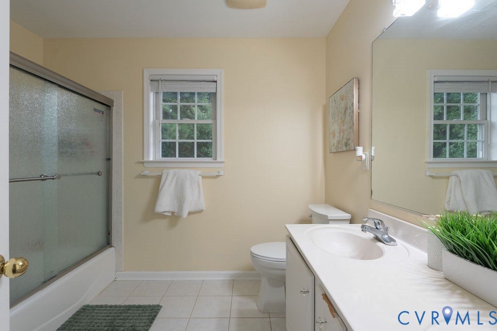 14107 Beachmere Road, Stoney Glen South, Chester, VA 23831 Bathroom featuring a window with privacy blinds, vanity with an integrated sink, large wall-mounted mirror, and a shower with sliding glass doors