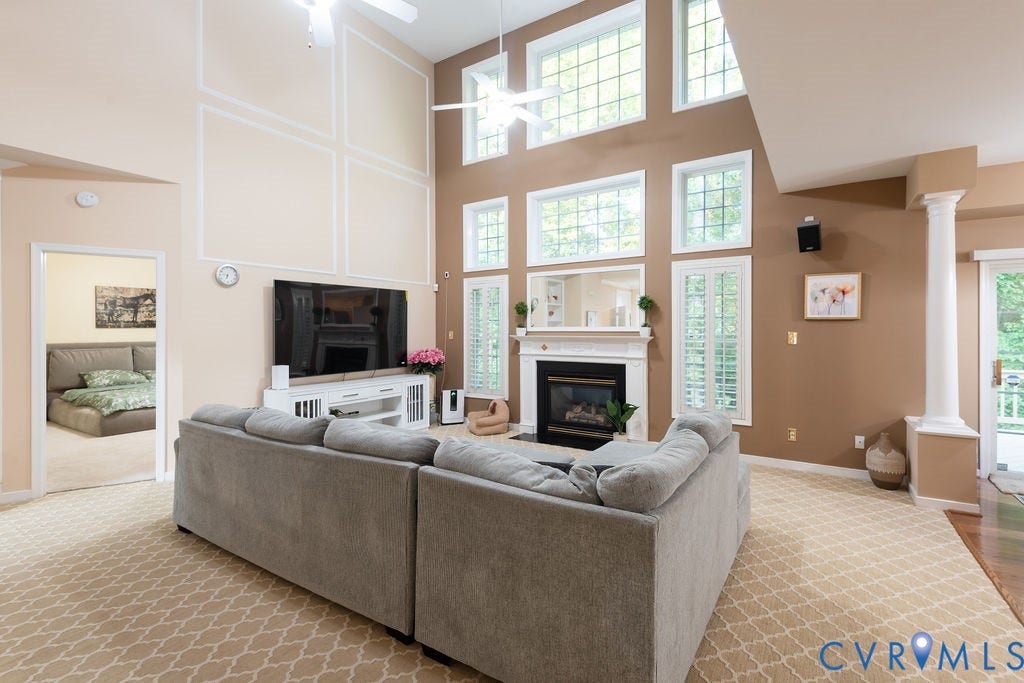 14107 Beachmere Road, Stoney Glen South, Chester, VA 23831 Two-story living area with decorative wall molding, a gas fireplace with a white mantel, and multiple windows with white shutters