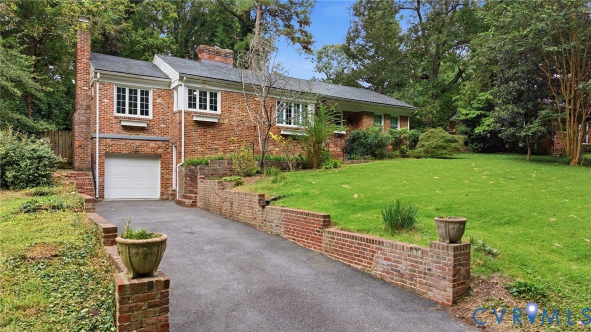 1427 Spring Grove Drive, Richmond, VA 23225 Brick exterior with multiple windows, attached garage, and a long asphalt driveway