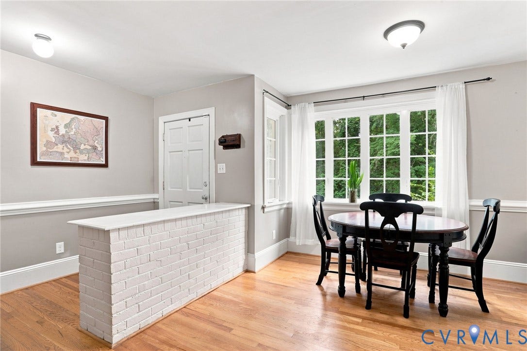 1427 Spring Grove Drive, Richmond, VA 23225 Hardwood flooring throughout, white brick half-wall feature, bay window with multiple panes, crown molding, and a solid core door