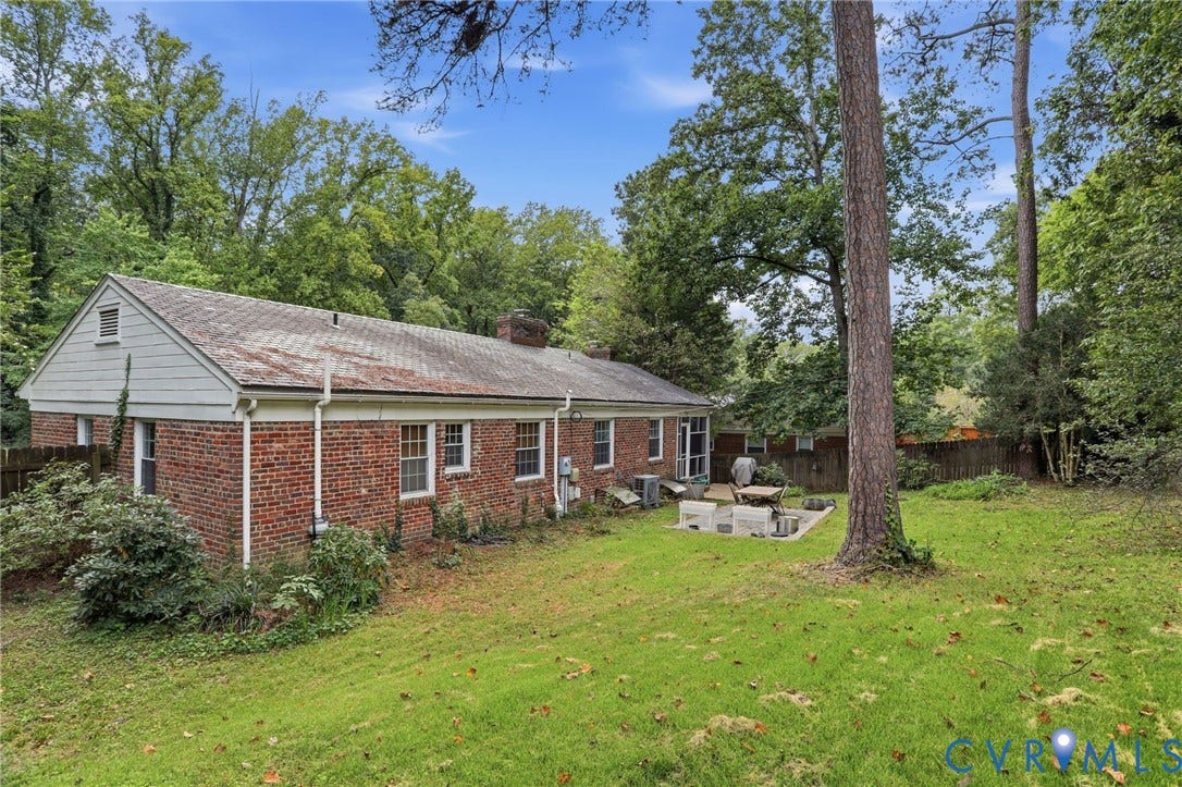 1427 Spring Grove Drive, Richmond, VA 23225 Expansive backyard with a large patio area, mature trees, and a brick exterior home with white trim