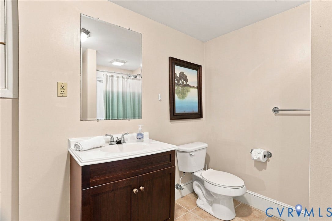 1427 Spring Grove Drive, Richmond, VA 23225 Vanity with a white integrated sink, chrome faucet, and dark wood-finish cabinetry