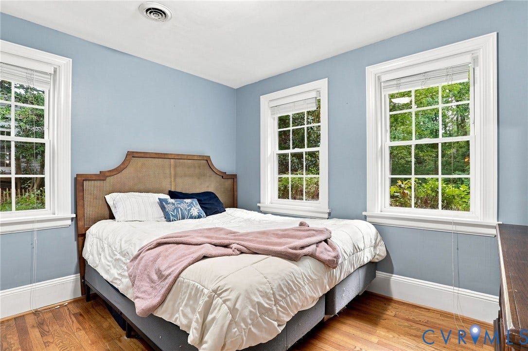 1427 Spring Grove Drive, Richmond, VA 23225 Hardwood flooring, two double-hung windows, crown molding, and light blue wall finish