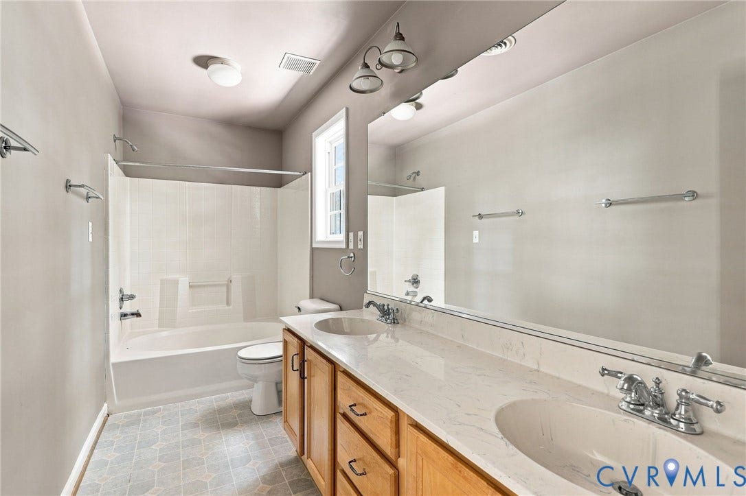 3522 Fairfield Road, Powhatan, VA 23139 Dual vanity with wood-finish cabinetry, a white countertop, and chrome fixtures
