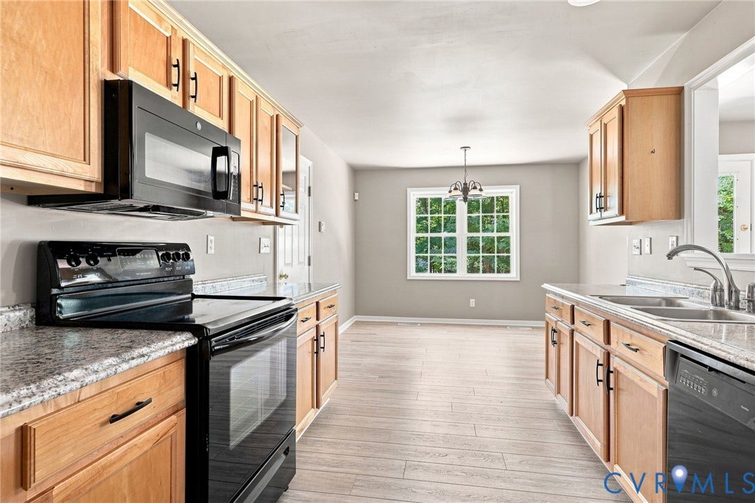 3522 Fairfield Road, Powhatan, VA 23139 Kitchen with wood-finish cabinetry, black appliances, light-toned countertops, and wood-finish flooring