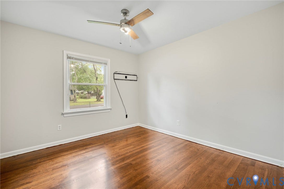 5322 Germain Road, Piney Knolls, Richmond, VA 23224 Hardwood flooring, painted walls, ceiling fan with light fixture, and a window providing natural light