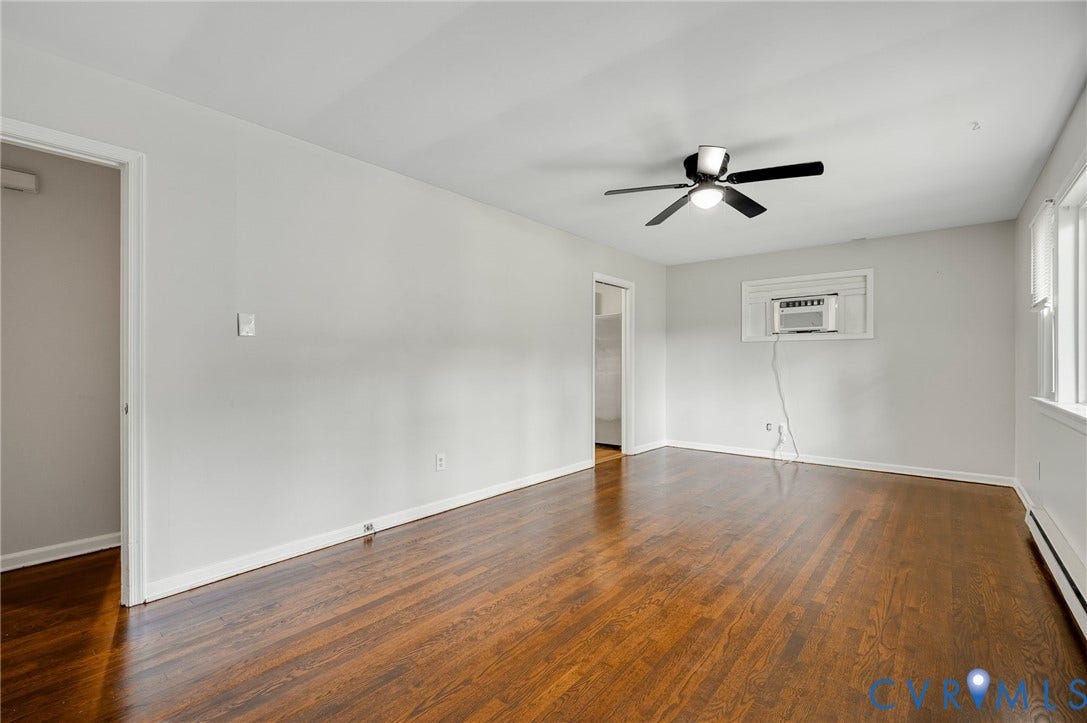 5322 Germain Road, Piney Knolls, Richmond, VA 23224 Hardwood flooring, white painted walls, ceiling fan, multiple windows with white trim, and a window-mounted air conditioning unit