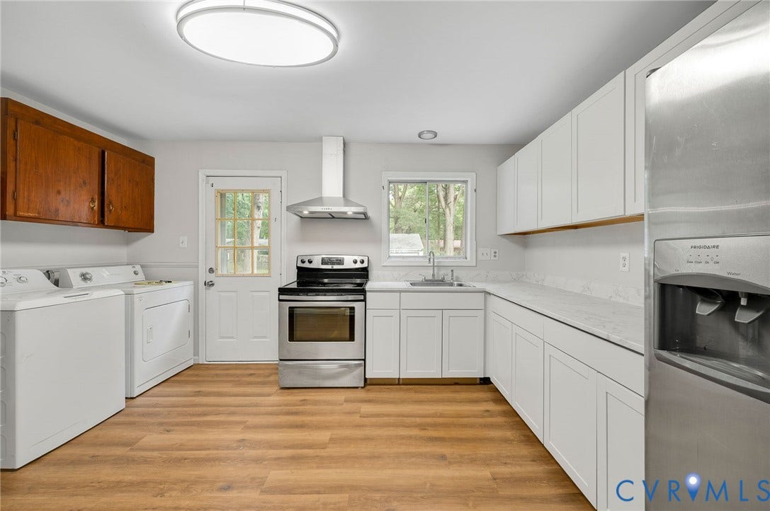 5322 Germain Road, Piney Knolls, Richmond, VA 23224 Kitchen featuring wood-finish flooring, white cabinetry, stainless steel appliances, and a built-in washer and dryer