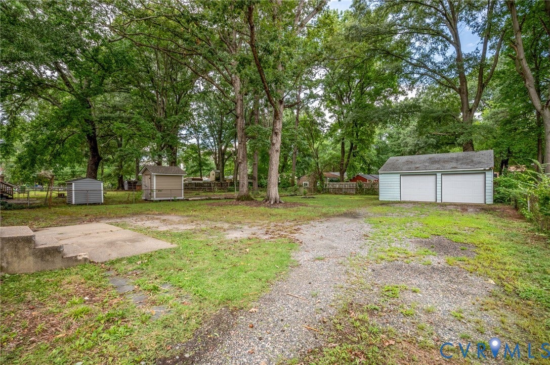 5322 Germain Road, Piney Knolls, Richmond, VA 23224 Detached two-car garage, two storage sheds, and mature trees on a spacious lot with a concrete patio