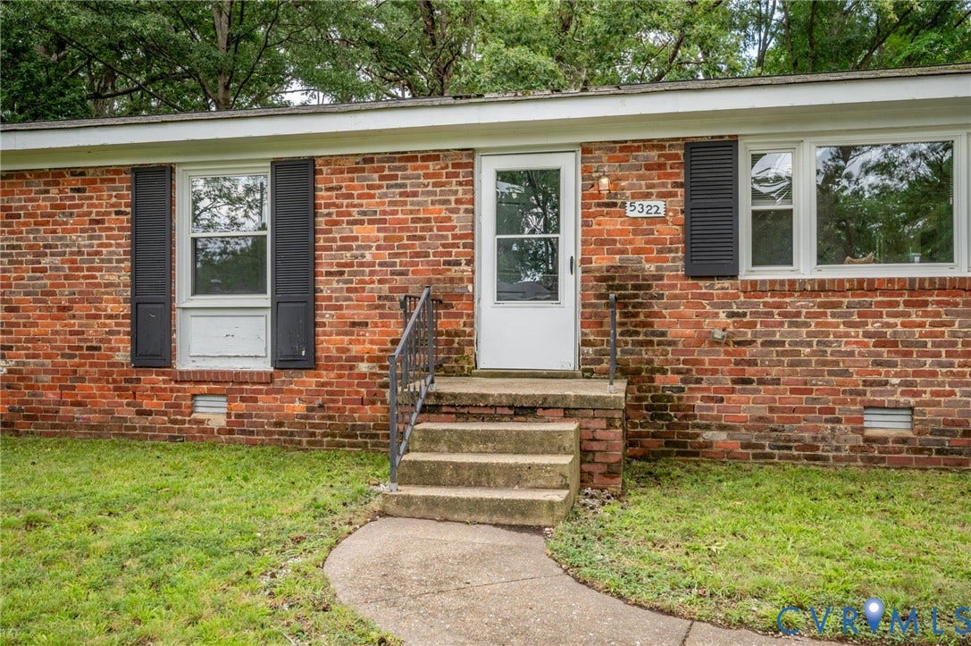 5322 Germain Road, Piney Knolls, Richmond, VA 23224 Brick exterior with white trim, front entry with storm door, concrete steps, and a curved concrete walkway