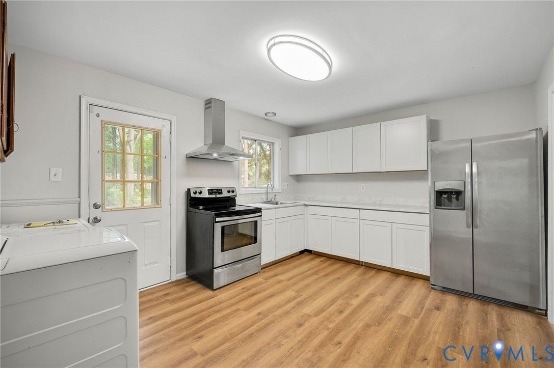 5322 Germain Road, Piney Knolls, Richmond, VA 23224 Kitchen featuring wood-finish flooring, white cabinetry, stainless steel appliances, and a windowed exterior door