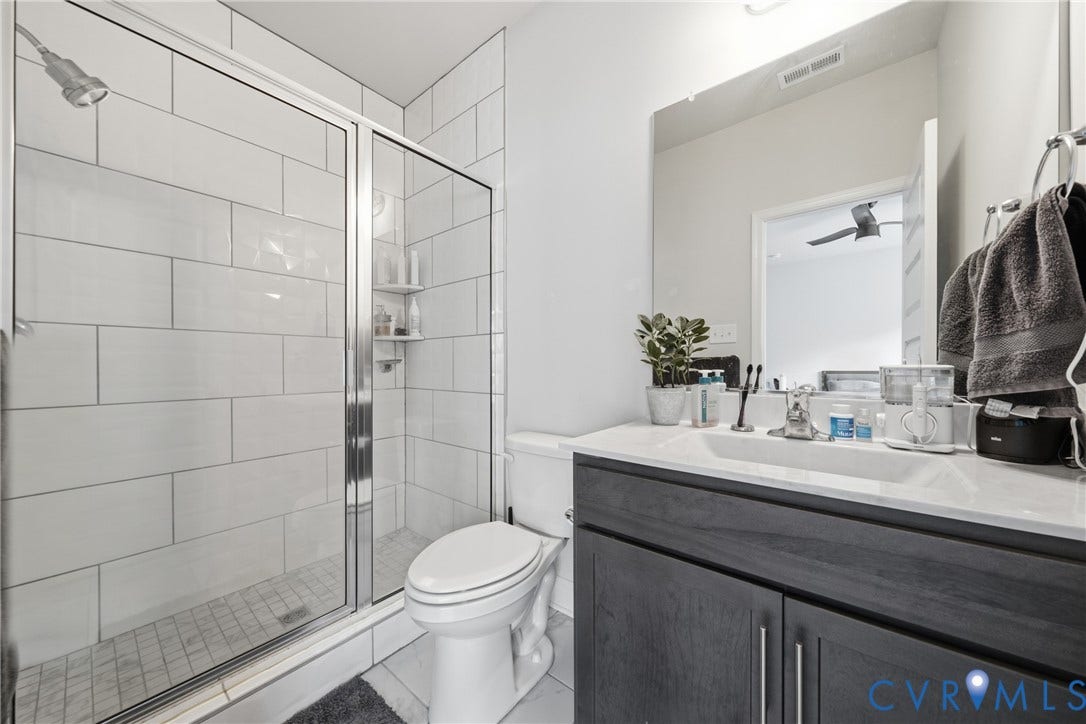 Glass-enclosed shower with subway tile surround and built-in shelving