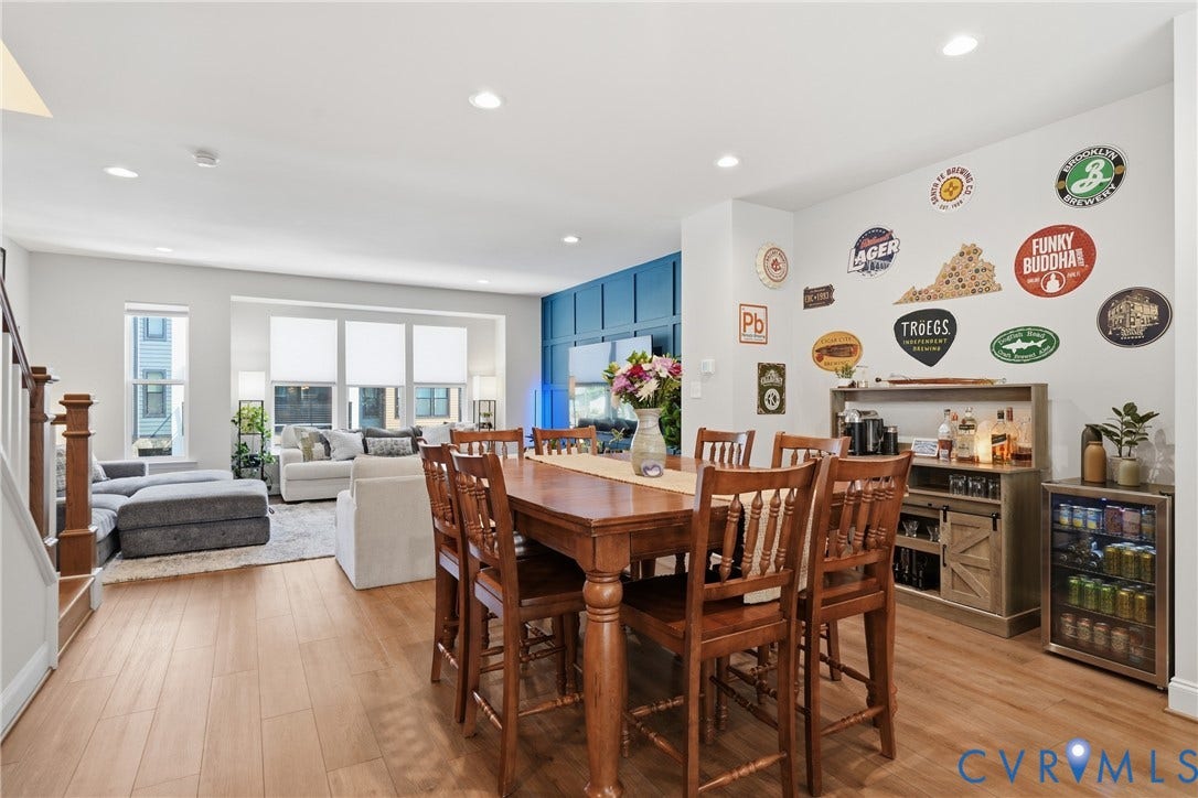 Wood-finish flooring, recessed lighting, and a prominent bay window