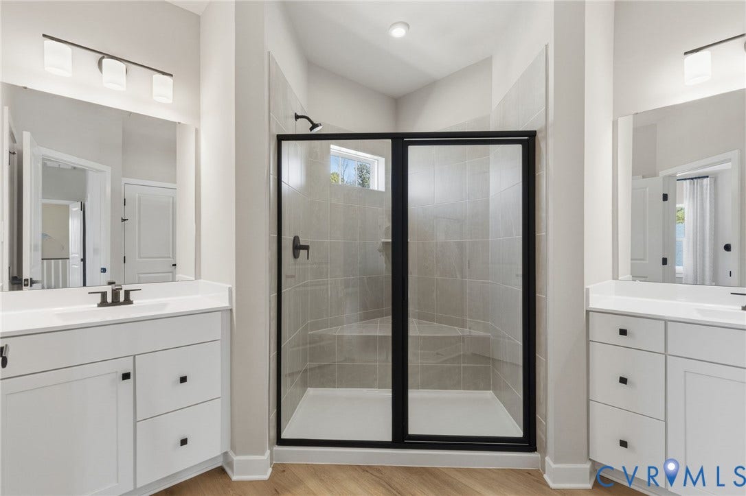 Dual white vanities with integrated sinks, quartz countertops, and matte black fixtures